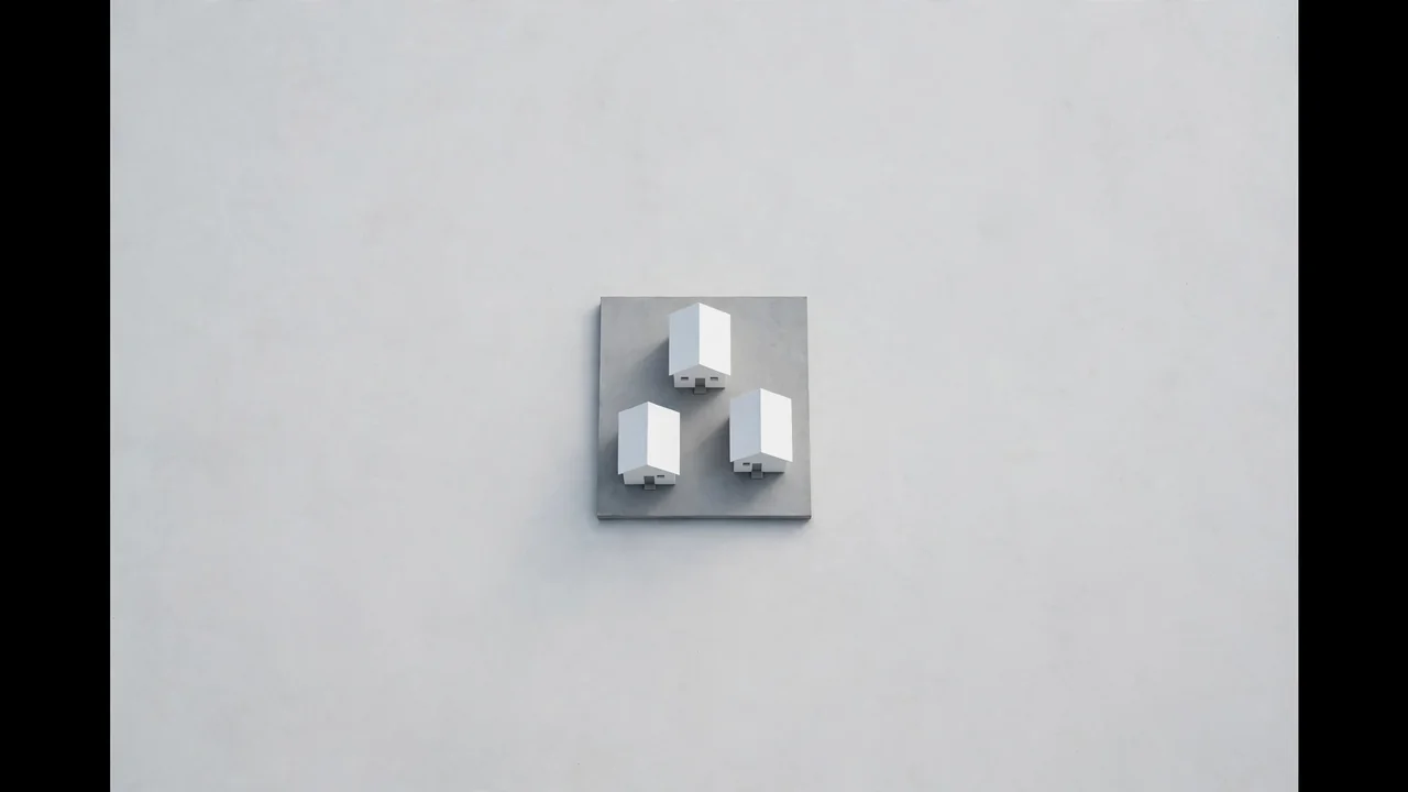 Three miniature houses sharing one foundation slab, aerial view