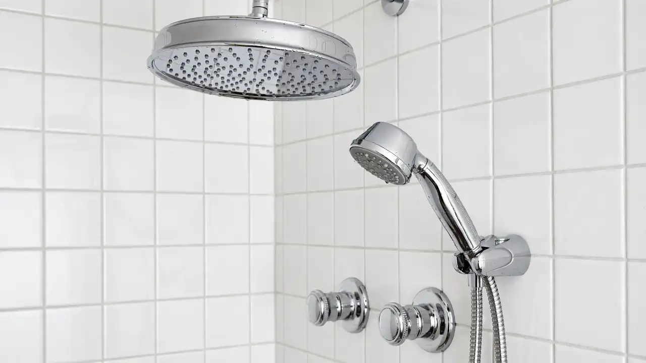 Close-up of a 2-in-1 shower combo showing the wide rainfall head and the detachable handheld sprayer