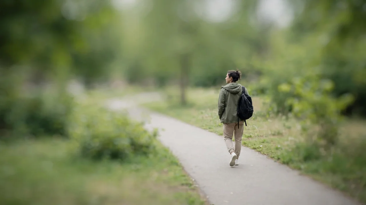 A person taking a quiet restorative walk in a park during a work break